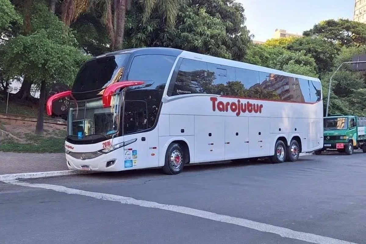 Ônibus da Tarojutur estacionado em uma rua arborizada